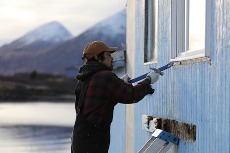 Marvin Agnot repairs the side of his home. (National Geographic/Lauren Bird Dixon)