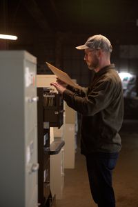 Journalist Dylan Taylor-Lehman is looks through case files during the production of "Cursed Gold: A Shipwreck Scandal." In 1989, maverick scientist Tommy Thompson stuns the world by recovering three tons of gold from a shipwreck deep in the Atlantic Ocean. What follows is a 30-year story of adventure, deception, and personal turmoil, taking him from venerated celebrity to infamous fugitive, and finally a defiant prisoner who refuses to give up his gold. (National Geographic)