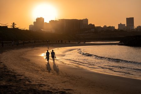 Issa Rae and Antoni Porowski walk on the beach in Dakar, Senegal. (National Geographic/John Wendle)