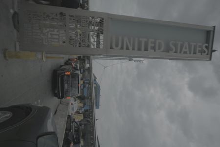 A pillar that says "UNITED STATES" stands tall next to cars waiting in line to cross the border at the San Ysidro border in San Diego, Calif. (National Geographic)