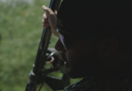 A CBP Agent holds a weapon while sitting in a vehicle in Mayaguez, P.R. (Lucky 8 TV/Paul Taggart)