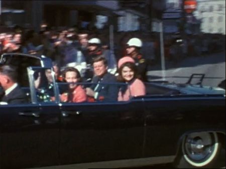 President John F. Kennedy and first lady Jaqueline Kennedy ride a Presidential limousine during a motorcade through the streets of Dallas, Nov. 22, 1963. (The Sixth Floor Museum at Dealey Plaza)