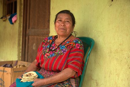 Dona Feliciana Yacqui poses for a portrait with her homemade tortillas in the Patzún Municipality, Guatemala. (National Geographic/Adnelly Marichal)