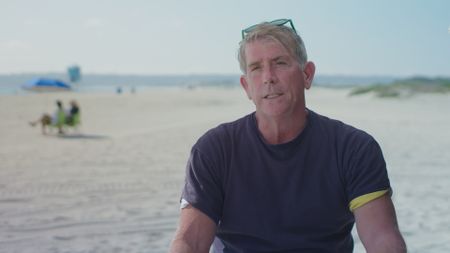 Phil Garn, shark attack survivor being interviewed on Coronado Beach, California as he recalls his encounter with a shark biting his flipper whilst he was out swimming in the ocean. (National Geographic)