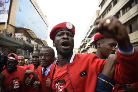 Musician turned politician Robert Kyagulanyi Ssentamu aka Bobi Wine (C) is joined by other activists in Kampala on July 11, 2018 in Kampala during a demonstration to protest a controversial tax on the use of social media. - Police fired live bullets and teargas to disperse a rowdy crowd during the protests.     (Photo credit should read ISAAC KASAMANI/AFP via Getty Images)