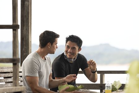 Antoni Porowski and Henry Golding taste the Ikan Semah. (Credit: National Geographic/Annice Lyn)