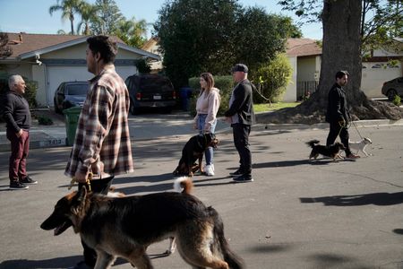 Cesar talks with Johnnie and Celestria as they hold Beast and other dogs are walked by in an exercise. (National Geographic)