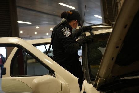 CBP Officers Hernandez and Hoffman work to dismantle the roof rack on a suspect's vehicle in search of smuggled drugs in Calexico, Calif. (National Geographic)