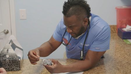 Dr. Hodges does a physical exam on Sis, the dove, who is presenting with breathing issues. (National Geographic for Disney)