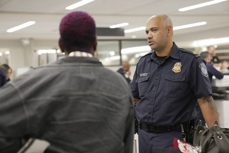 CBP Supervisory Officer Pacheco questions a passenger while going through their belongings in Atlanta, Ga. (National Geographic)