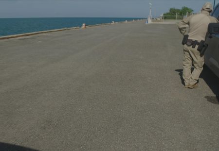 A CBP Agent is waiting on the side of a vehicle by the Marina  in Mayaguez, PR. (Lucky 8 TV)