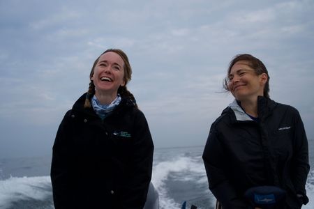 Dr. Megan Winton and Dr. Alisa “Harley” Newton laugh together at the back of the research boat. (National Geographic/Brandon Sargeant)