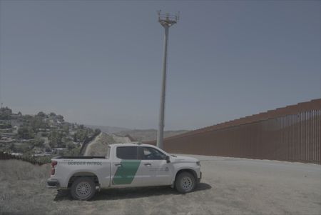 A Border Patrol vehicle is parked next to the U.S./Mexico border wall in San Diego, Calif. (National Geographic)