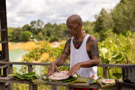 Peter prepares Ikan Semah for Henry Golding and Antoni Porowski. (Credit: National Geographic/Annice Lyn)