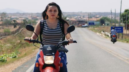 Myllena riding her moped in Iracema, Brazil. (National Geographic)
