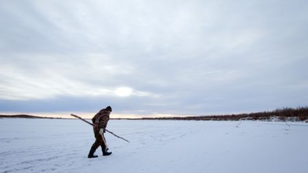 Chip Hailstone tests the frozen lake ice to make sure it will be safe for his family to ice fish at night. (BBC Studios/Dwayne Fowler)