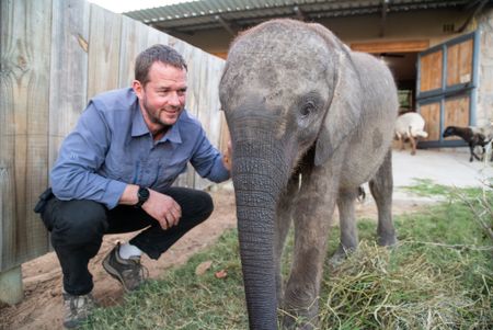 Giles Clark and Phabeni the elephant orphan. (National Geographic/Cherique Pohl)