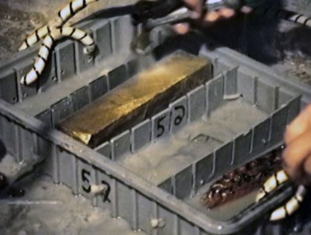 Gold bars in plastic retrieval boxes are placed on deck after being found and brought up from the bottom of the seabed off the coast of North Carolina, USA. In 1989, maverick scientist Tommy Thompson stuns the world by recovering three tons of gold from a shipwreck deep in the Atlantic Ocean. What follows is a 30-year story of adventure, deception, and personal turmoil, taking him from venerated celebrity to infamous fugitive, and finally a defiant prisoner who refuses to give up his gold. (Recovery Limited Partnership Liquidating Trust)