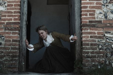 Mary Dunbar falls in a doorway, seemingly afflicted by evil magic. (Dash Productions Services LTD/Antoan Ivanov)