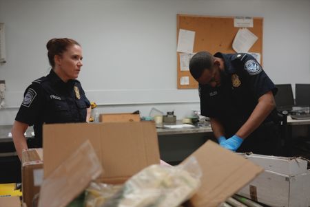 CBP Officers Pirollo and Keller work on opening packages to look for smuggled contraband in Philadelphia. (National Geographic)