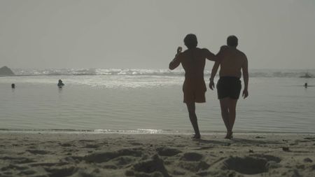 Caleb Swanepoel and his brother, Alex Swanepoel walking on the beach towards the ocean. (National Geographic/Robert Cowling)