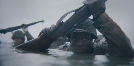 Private Henry Parham (played by Ishmel Bridgeman) wades into Omaha Beach in a scene of a WW2 historic reenactment production for "Erased: WW2's Heroes of Color." Parham served with the 320th Barrage Balloon Battalion on D-Day. (National Geographic)