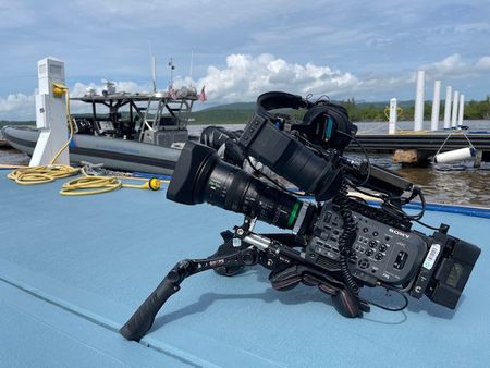 A film camera is resting on the ground next to a parked boat at a dock Fajardo, P.R. (Lucky 8 TV/Ivan Leon)