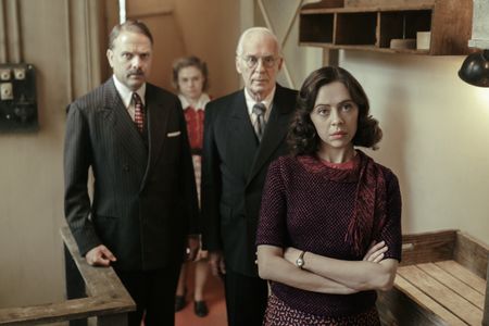 A SMALL LIGHT - (From left) Nicholas Burns as Mr. Kugler, Sally Messham as Bep, Ian McElhinney as Mr. Kleiman, and Bel Powley as Miep Gies in A SMALL LIGHT. (Credit: National Geographic for Disney/Dusan Martincek)