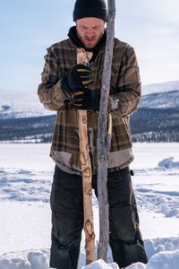 Johnny Rolfe checks his fishing lines underneath the ice. (BBC Studios Reality Productions/Patrick Henderson)