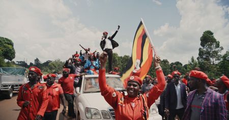 Bobi Wine standing on top of a car at a rally.   (Mandatory photo credit:  Southern Films)