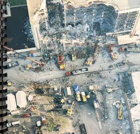 An aerial photograph shows the damage to the Alfred P. Murrah Federal Building, surrounded by search and rescue team vehicles and equipment, April 19, 1995, in Oklahoma City, Okla. (Courtesy The Stephen Jones Oklahoma City Bombing Archive, Dolph Briscoe Center, at the University of Texas)