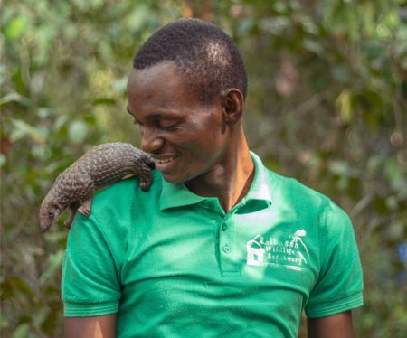 Beyan Borbor holding Wallah the pangolin on his shoulder. (Big Wave Productions)