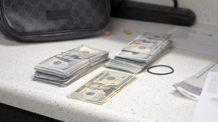 $13,040 worth of seized currency is pictured on a countertop after it was apprehended during an HSI operation in San Diego, Calif. (National Geographic)