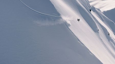Travis Rice does a backflip as he snowboards on a mountain in Alaska.  (photo credit: Travis Rice, Inc)