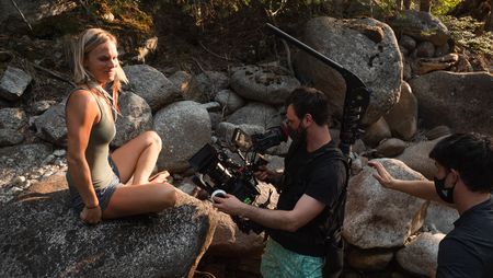 Angel Collinson smiles as cinematographer Nick Kraus captures the shot and assistant cameraperson Galen Murray spots him.  (National Geographic/Elena Gaby)