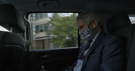 Dr. Anthony Fauci talks on the phone in his security detail car. Dr. Fauci received security after receiving death threats in 2020.  (National Geographic for Disney+)