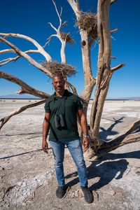 Christian Cooper stands in front of a dead tree with nests that used to be homes to Great Blue Herons. The Salton Sea has long been a vital stop for migrating birds. (National Geographic/Jon Kroll)