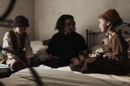 A young boy and a young girl sit on a bed making accusations of witchcraft to a local minister. (Dash Productions Services LTD/Antoan Ivanov)