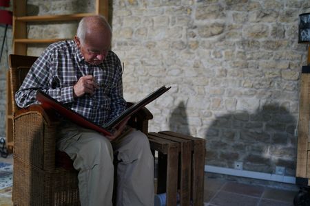 Stéphane Bourgoin is a French author and renowned specialist on serial killers, who since 2019 has been at the center of an internet-led controversy spearheaded by a group of anonymous true crime fans.  Here, Bourgoin looks at family photos during the production of "Killer Lies: Chasing a True Crime Con Man," a documentary series about obsession and deception, following the unraveling of Stephane Bourgoin’s career as a best-selling author and serial killer expert. (National Geographic/Ben Selkow)