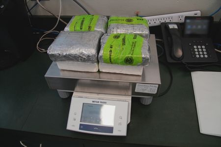 Multiple packages of suspected narcotics found smuggled in a suspect's vehicle are weighed on a scale in Pharr, Texas. (National Geographic)