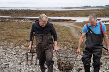 Gordon Ramsay and Oyster Farmer Diarmuid Kelly carry a basket of oysters. (National Geographic/Justin Mandel)