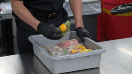 A CBP agriculture specialist inspects multiple agriculture items that were found in a traveler's luggage in Atlanta, Ga. (National Geographic)