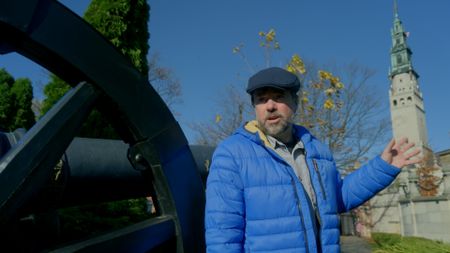 Tony Pollard outside jasna gora wearing blue jacket and flat cap. (National Geographic)