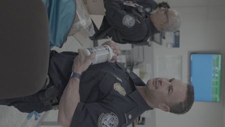 Chief Augustino inspects a bottle of pills found in a courier's belongings in Dulles, Va. (National Geographic)