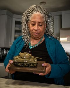 E.G. McConnell‘s daughter, Carole Johnson, looks at a model tank during an interview at her home in N.Y. Private First Class E.G. McConnell served with the 761st Black Panther Tank Battalion in WW2. (National Geographic/Fabian Mandujano)