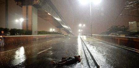 Manila, Philippines - A body on the highway in the rain. (Ezra Acayan)