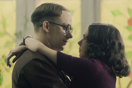 A SMALL LIGHT - Jan and Miep Gies, played by Joe Cole and Bel Powley, embrace as seen in A SMALL LIGHT. (Credit: National Geographic for Disney/Dusan Martincek)