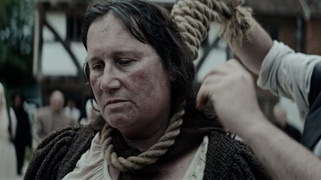 Elizabeth Clarke has a noose tightened around her neck. Villagers watch in the background. (Dash Pictures/Samuel Purcell, Oliver Watts)