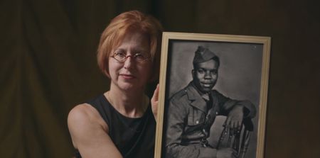 American journalist and photographer Linda Hervieux holds a portrait of Private Henry Parham. She got to know Parham and his relatives while spending years researching her book about the 320th. Private Parham served with the 320th Barrage Balloon Battalion on D-Day. (National Geographic)