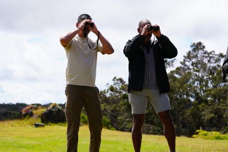 Biologist Raymond McGuire and Christian Cooper look through binoculars at wild Nēnē at the Hawaii Island Nēnē Sanctuary. (National Geographic for Disney/Troy Christopher)